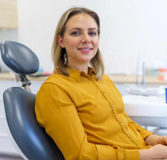 Female patient smiling during dental exam in treatment chair